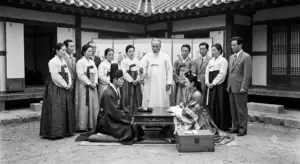 1950년대 한국 양가 가문의 어른들이 지켜보는 가운데 한옥 마당에서 엄숙하게 거행되는 전통 중매결혼 식의 장면